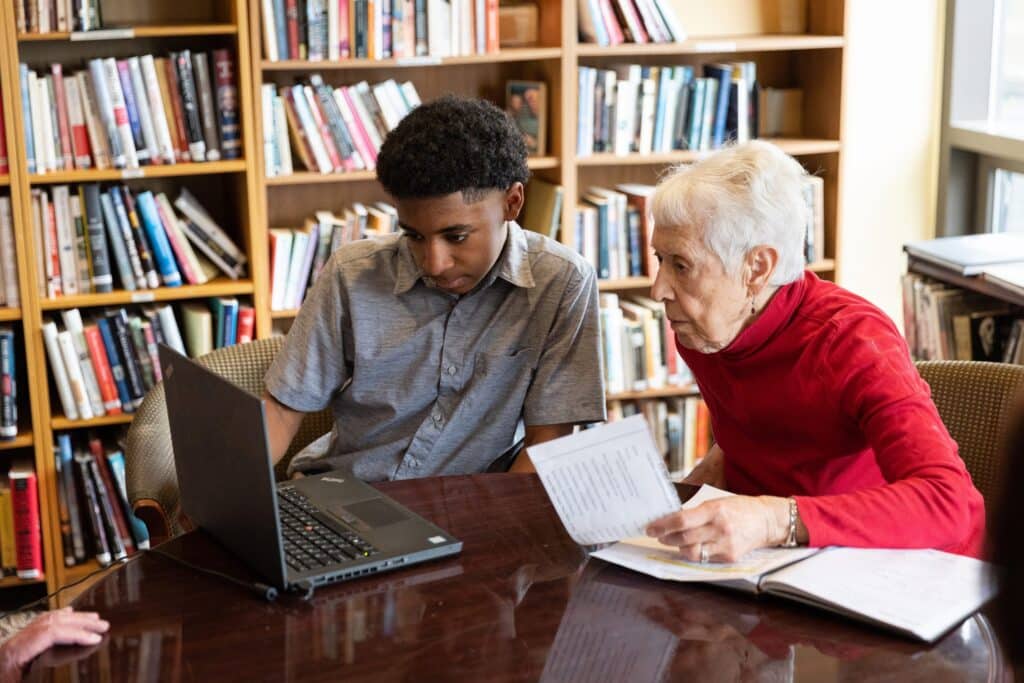Graham Bennett, 14, teaches Riki Jursik, right, how to use her laptop.